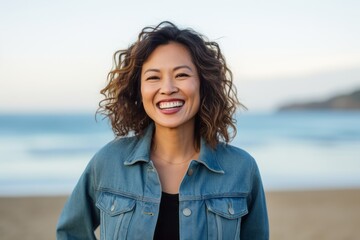 Portrait of a smiling young woman on the beach looking at camera