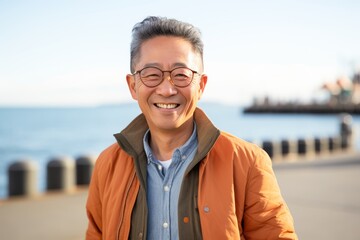 Portrait of happy asian senior man smiling at the seaside