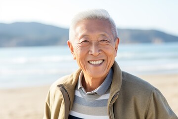 Fototapeta na wymiar Portrait of smiling senior man standing on beach on a sunny day