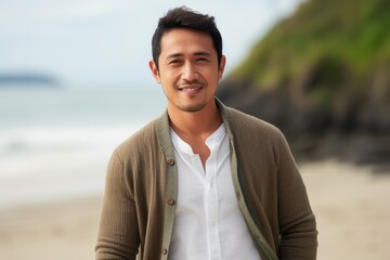 Portrait of a handsome young asian man smiling at the beach