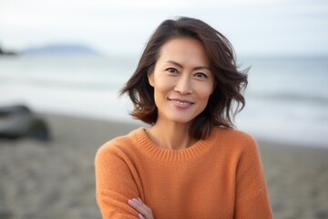 Portrait of a beautiful Asian woman smiling at the camera on the beach