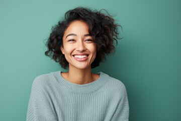 Obraz premium Portrait of a Indonesian woman in her 20s in an abstract background wearing a cozy sweater
