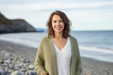 Portrait of a smiling woman standing on the beach at the seaside
