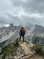 Fototapeta premium Adventurous hiker standing atop a mountain, looking out over the vast landscape below