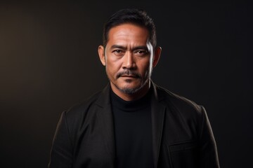 Naklejka premium Medium shot portrait of a Indonesian man in his 40s in an abstract background wearing a chic cardigan