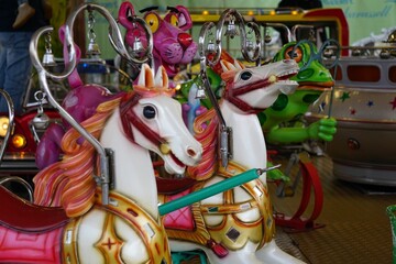 a group of carousel horses and other toys at a fair