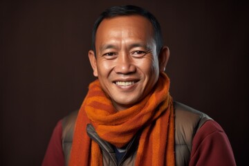 Portrait of a Indonesian man in his 40s in an abstract background wearing a charming scarf