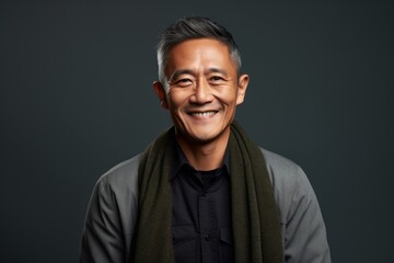 Obraz premium Portrait of a Indonesian man in his 50s in an abstract background wearing a chic cardigan