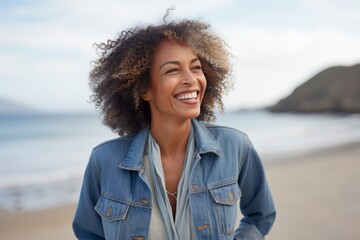 Portrait of a smiling young woman with afro hairstyle at the beach