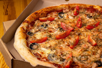 baked hot pizza Tuna. Close-up of pizza stuffed with tuna. Pizza in a cardboard box.