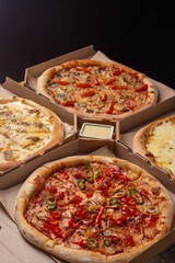 Pizza in boxes. A set of different pizzas in paper boxes. range of restaurant, pizzeria. Menu.