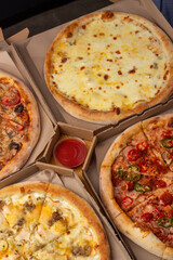 Pizza in boxes. A set of different pizzas in paper boxes. range of restaurant, pizzeria. Menu.
