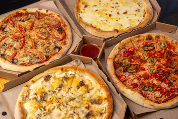 Pizza in boxes. A set of different pizzas in paper boxes. range of restaurant, pizzeria. Menu.