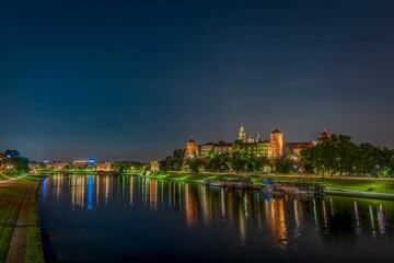 Naklejka premium Wawel Royal Castle surrounded by a lake in the evneing in Krakow, Poland