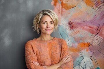 Portrait of a Russian woman in her 40s in an abstract background wearing a cozy sweater