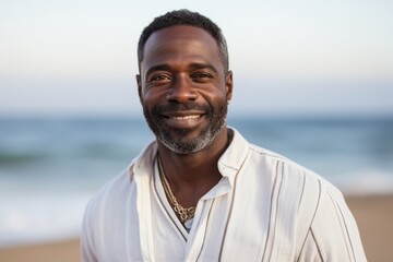 Portrait of smiling man standing on beach at the beach in the sunshine