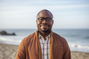 Portrait of smiling young man with eyeglasses standing on beach