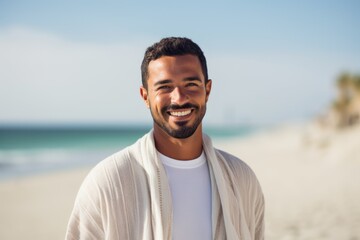 Portrait of smiling young man standing on beach at the day time