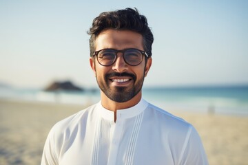 Portrait of smiling man with eyeglasses standing on the beach
