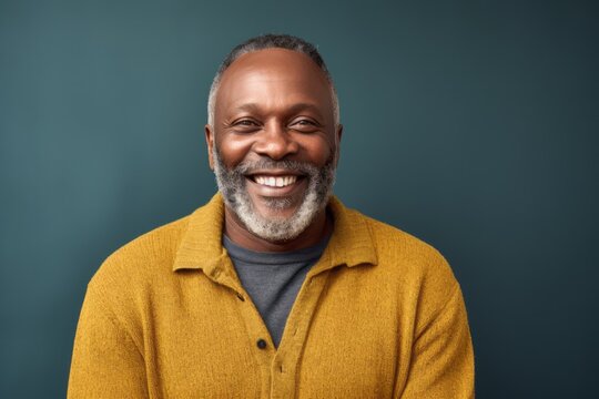 Medium shot portrait of a Nigerian man in his 50s in an abstract background wearing a chic cardigan