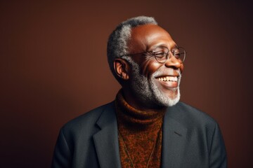 Portrait of a Nigerian man in his 60s in an abstract background wearing a chic cardigan