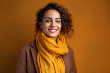 Portrait of a Saudi Arabian woman in her 40s in an abstract background wearing a charming scarf