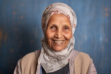 Portrait of a Saudi Arabian woman in her 80s in an abstract background wearing a denim jacket