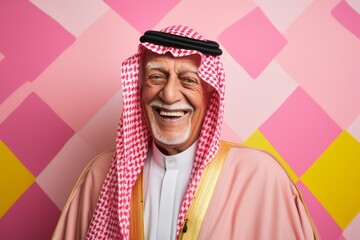 Portrait of a Saudi Arabian man in his 80s in an abstract background wearing a chic cardigan