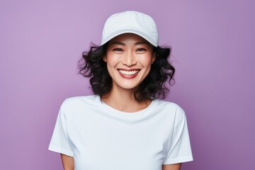 Portrait of a Chinese woman in her 40s in a pastel or soft colors background wearing a cool cap or hat