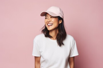 Portrait of a Chinese woman in her 40s in a pastel or soft colors background wearing a cool cap or hat