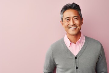 Portrait of a Chinese man in his 40s in a pastel or soft colors background wearing a chic cardigan