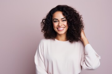 Portrait of a Saudi Arabian woman in her 30s in a pastel or soft colors background wearing a snuggly pajama set