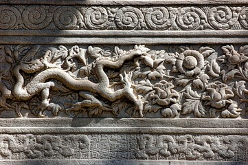 Mystical and majestic dragon depicted on a stone wall backdrop, with vibrant floral design