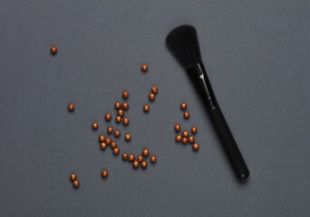 Black make-up brushes with powder balls on a dark background