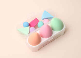 Different Make-up sponges, cosmetic blenders set on beige background. Beauty products.