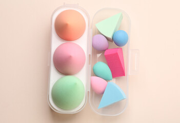 Different Make-up sponges, cosmetic blenders set on beige background. Beauty products.
