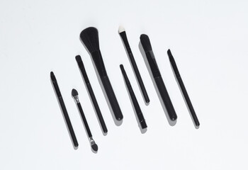 Set of black make-up brushes on white background with shadow