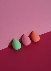 Makeup sponge blenders on a pink background with shadow. Beauty concept. Creative layout, minimalism