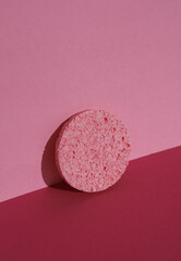 Make-up remover sponge on a pink background with shadow. Beauty concept. Creative layout, minimalism