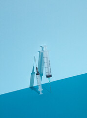 Syringes on blue background with shadow. Creative layout