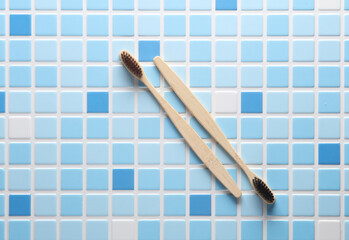 Bamboo eco toothbrushes on blue tiles. Top view