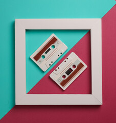 Retro Audio cassettes in white frame on pink blue background. Creative layout. Minimalism