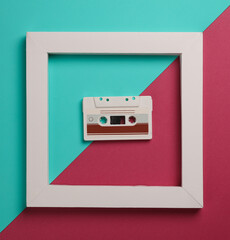 Fototapeta na wymiar Retro Audio cassette in white frame on pink blue background. Creative layout. Minimalism
