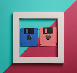 Retro floppy disks in white frame on pink blue background. Creative layout. Minimalism