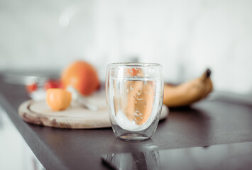 Close up glass of water and fruits on countertop in kitchen