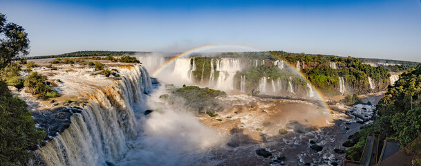 Perfect rainbow over Iguazu Waterfalls, one of the new seven natural wonders of the world in all its beauty viewed from the Brazilian side - traveling South America - Panorama