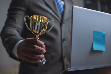 Businessman, success, company president Holding an outstanding trophy for corporate development of an investment company
