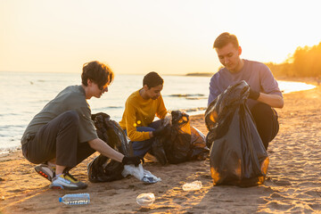 Earth day. Volunteers activists team collects garbage cleaning of beach coastal zone. Group of...