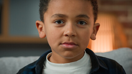 Portrait sad cute little African American boy looking down look at camera. Close up ethnic...
