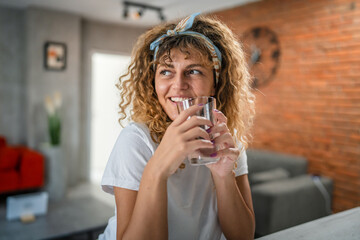 one adult caucasian woman sit at home hold glass of water happy smile